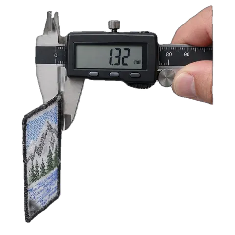Caliper measuring 1.32 millimetres of flat embroidery stitch on an ordinary patch